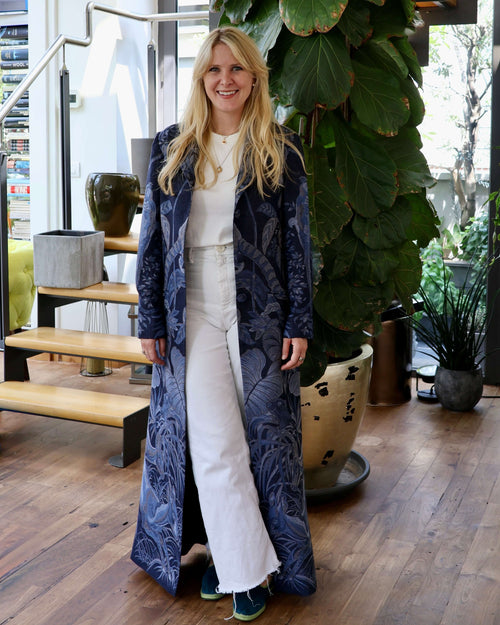 Modella che indossa il Cappotto Delhi Blu lungo in cashmere e seta di bambù, in un ambiente elegante e naturale.